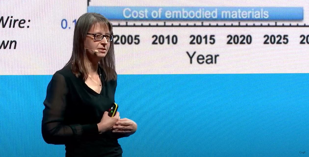 Professor Speller wearing a headset and standing in front of one of her CogX lecture slides