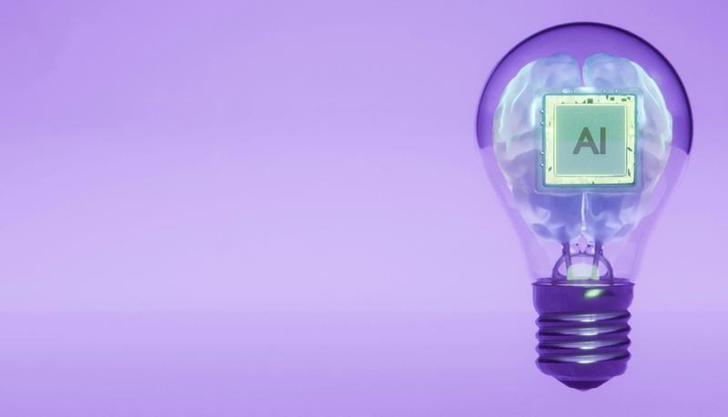 A lightbulb containing a human brain shape and a microchip with bearing the letters 'AI'