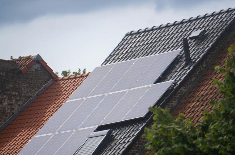 A terraced row of rooftops with solar panels installed on the middle roof