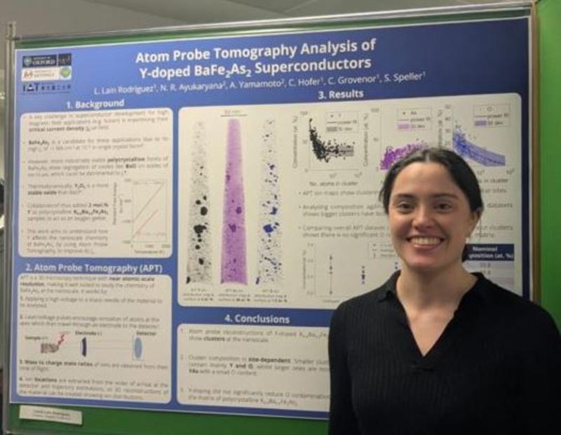 laura Lain Rodriguez, smiling, and standing next to her winning poster