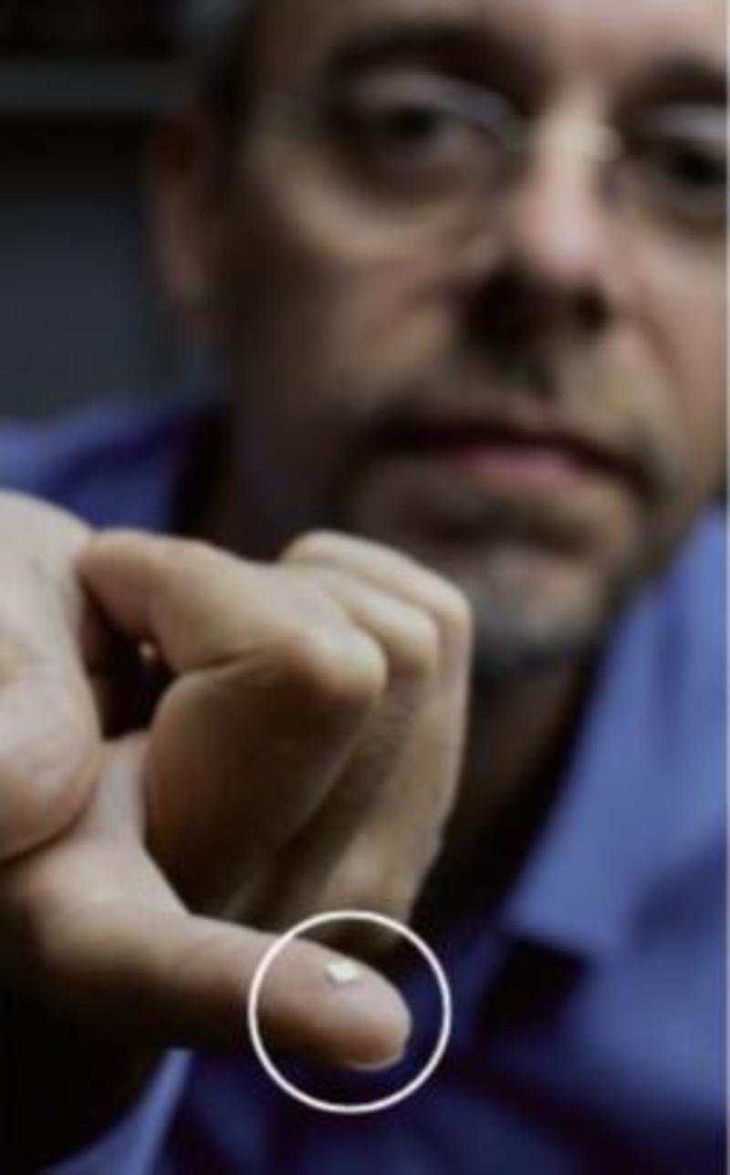 Professor Jason Smith with a 3x3mm microcavity substrate balanced on his finger