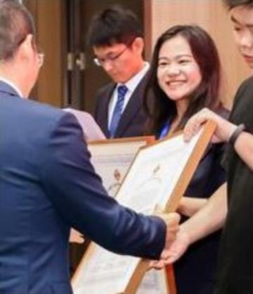 Yan Wang with her certificate, and smiling