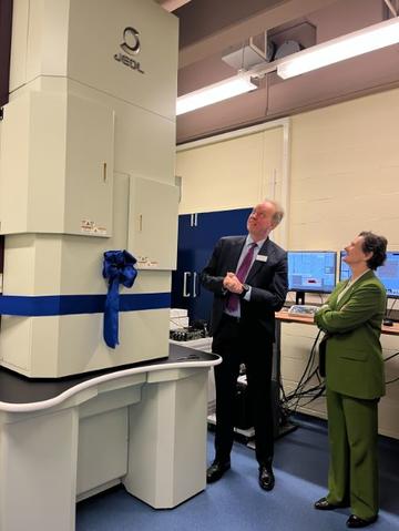 the VC and Professor Nellist viewing the JEOL EM (with ribbon and bow attached) before the official opening on 17 March 2025